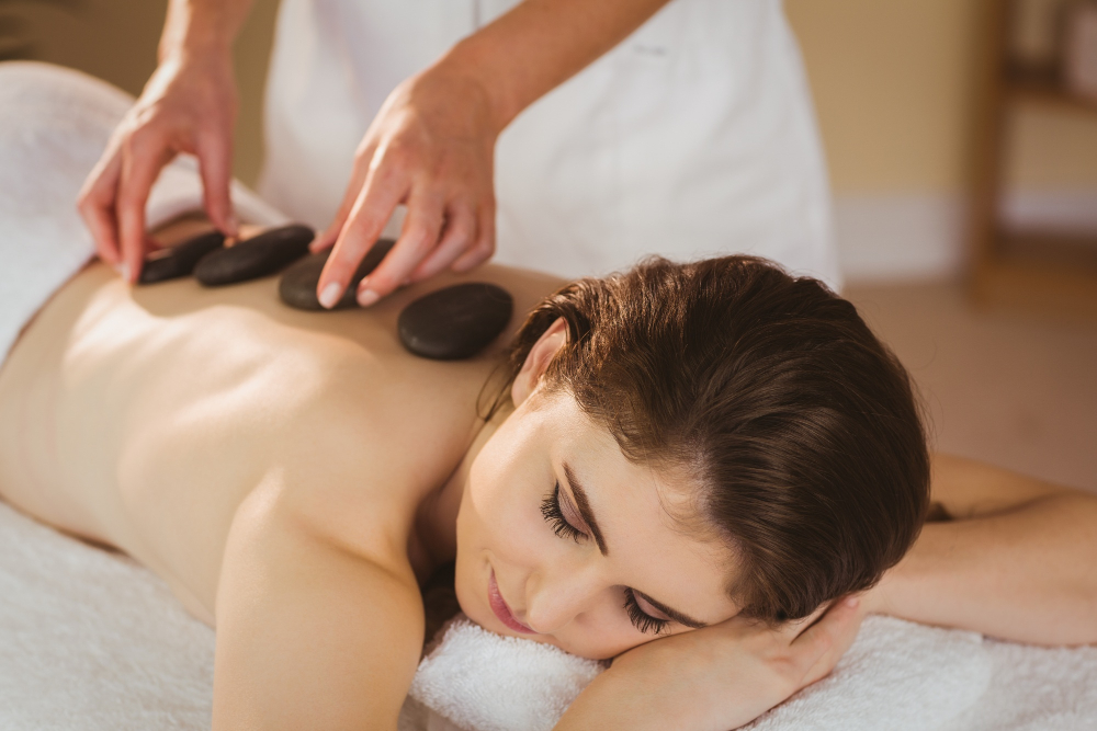 A Red Peony therapist performing a hot stone massage